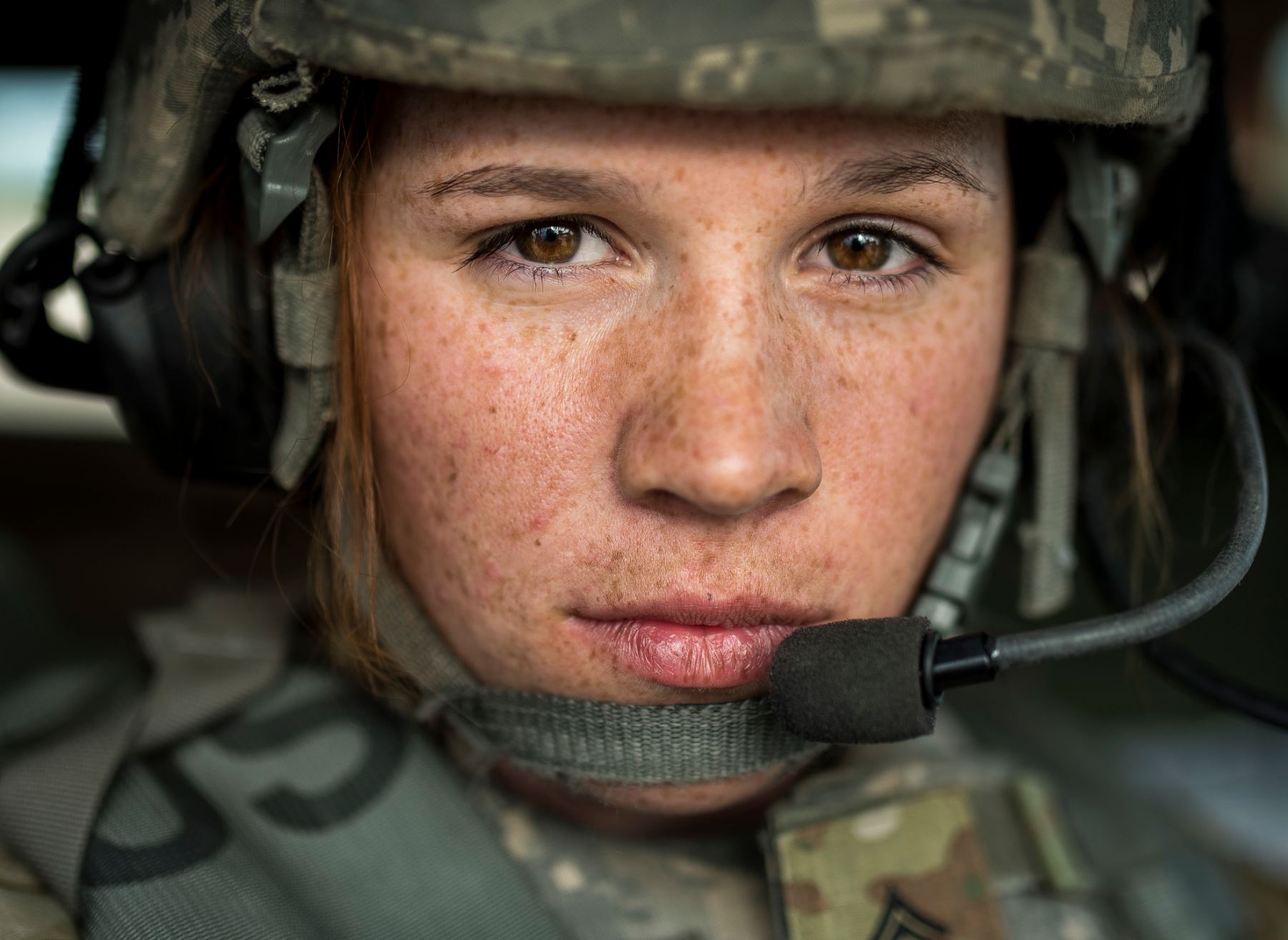 Soldier in a combat helmet and headset, looking directly at the camera